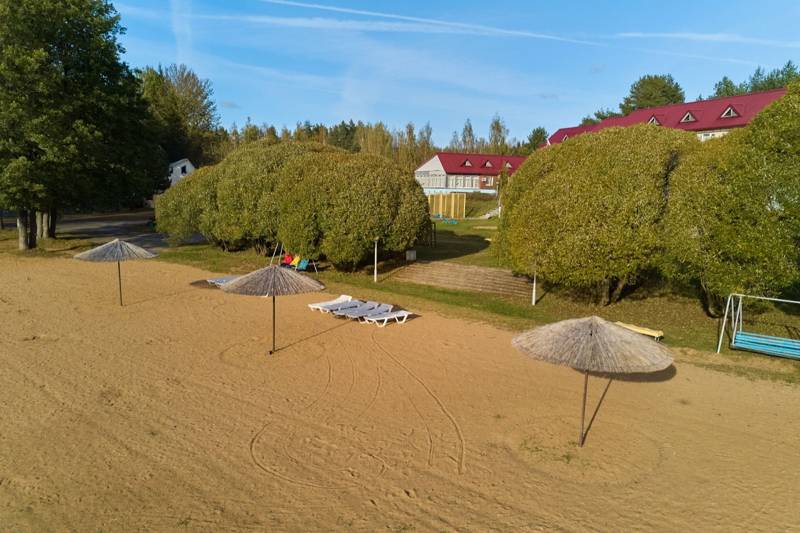 Пляж с зонтами и корпус на холме